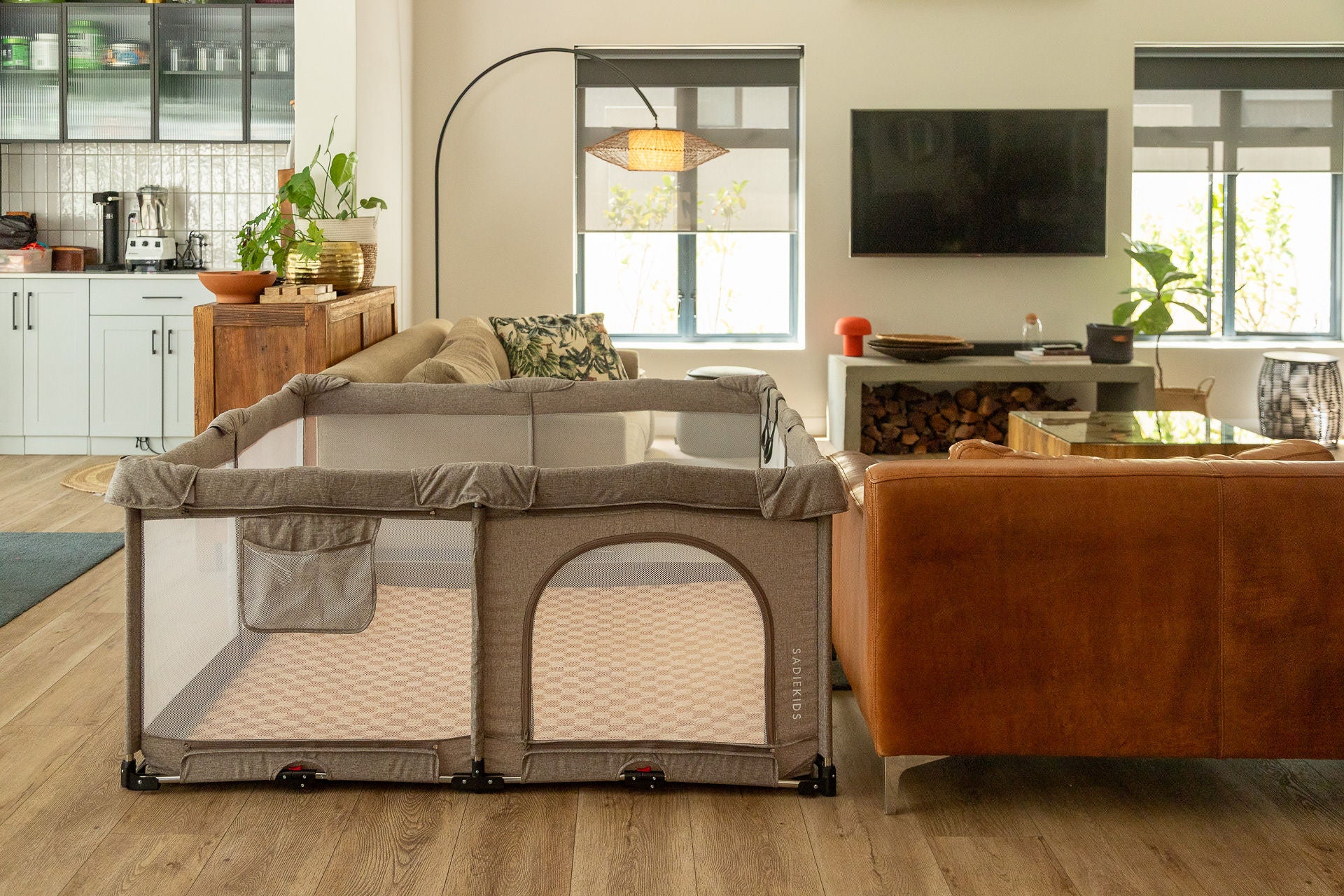 Portable playpen in a living room setting with furniture and decor.
